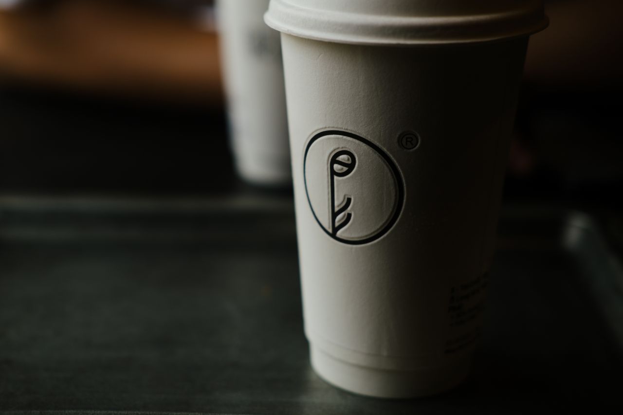 A minimalist coffee cup with unique design in a dark setting, capturing a moody cafe atmosphere.